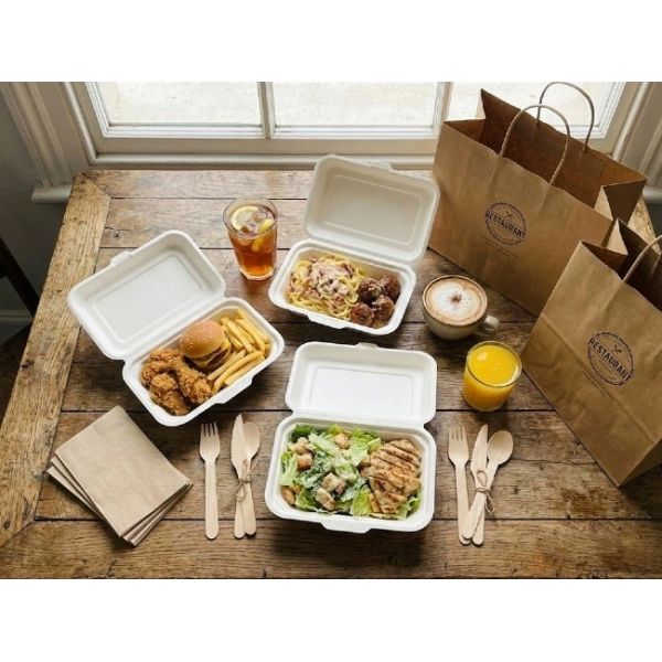 Stack of secure bagasse clamshell boxes packed in a delivery bag, featuring interlocking design to prevent slipping during food delivery.