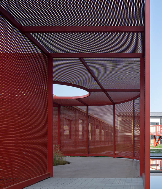 Close-up view of perforated metal sheet showing different hole patterns and surface finish