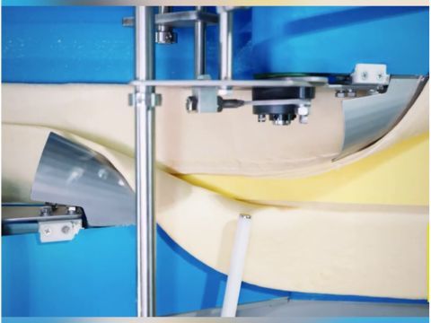 Industrial fat enclosing system with mechanical folding shoes wrapping the outer edges of the dough band over the extruded butter sheet.